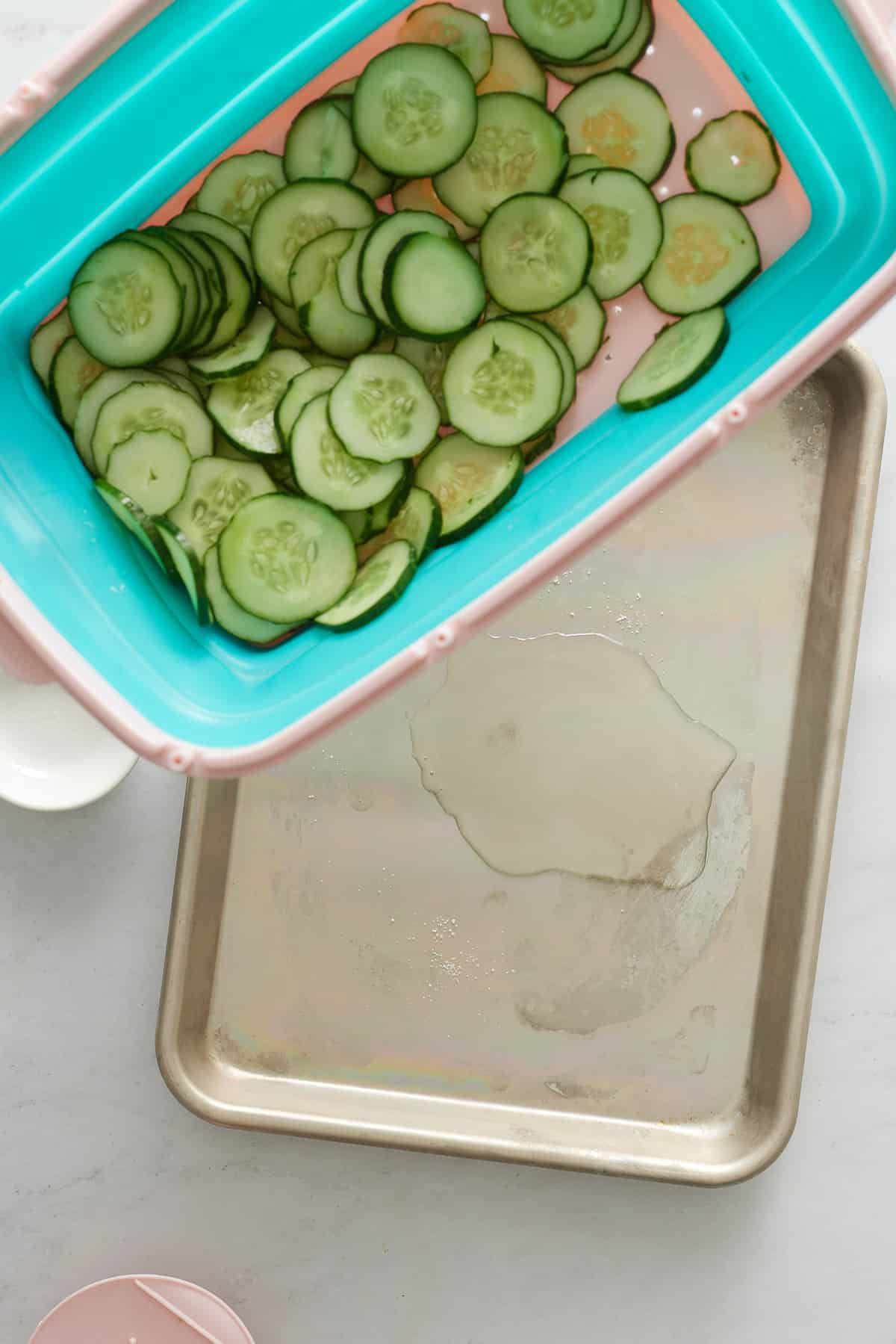 Draining the water from the cucumber slices.