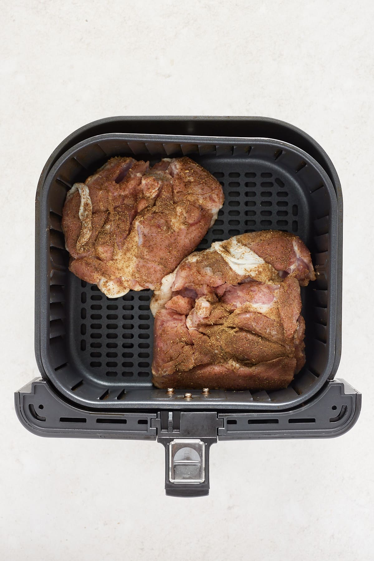 prepped turkey thighs skin side down in air fryer basket