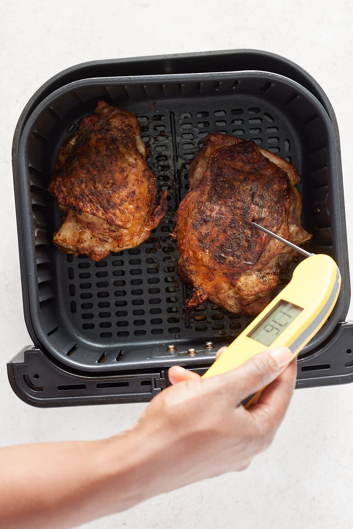 checking the temperature of the turkey thigh with a meat thermometer