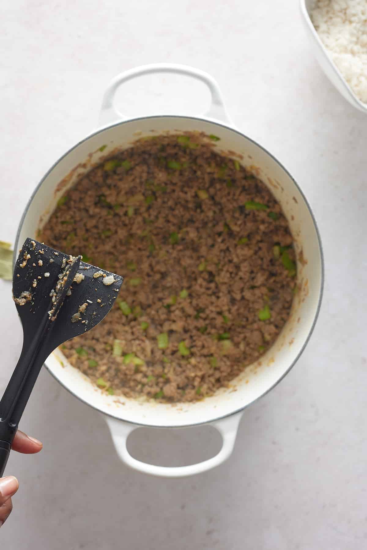 large pot with sauteed meat and celery