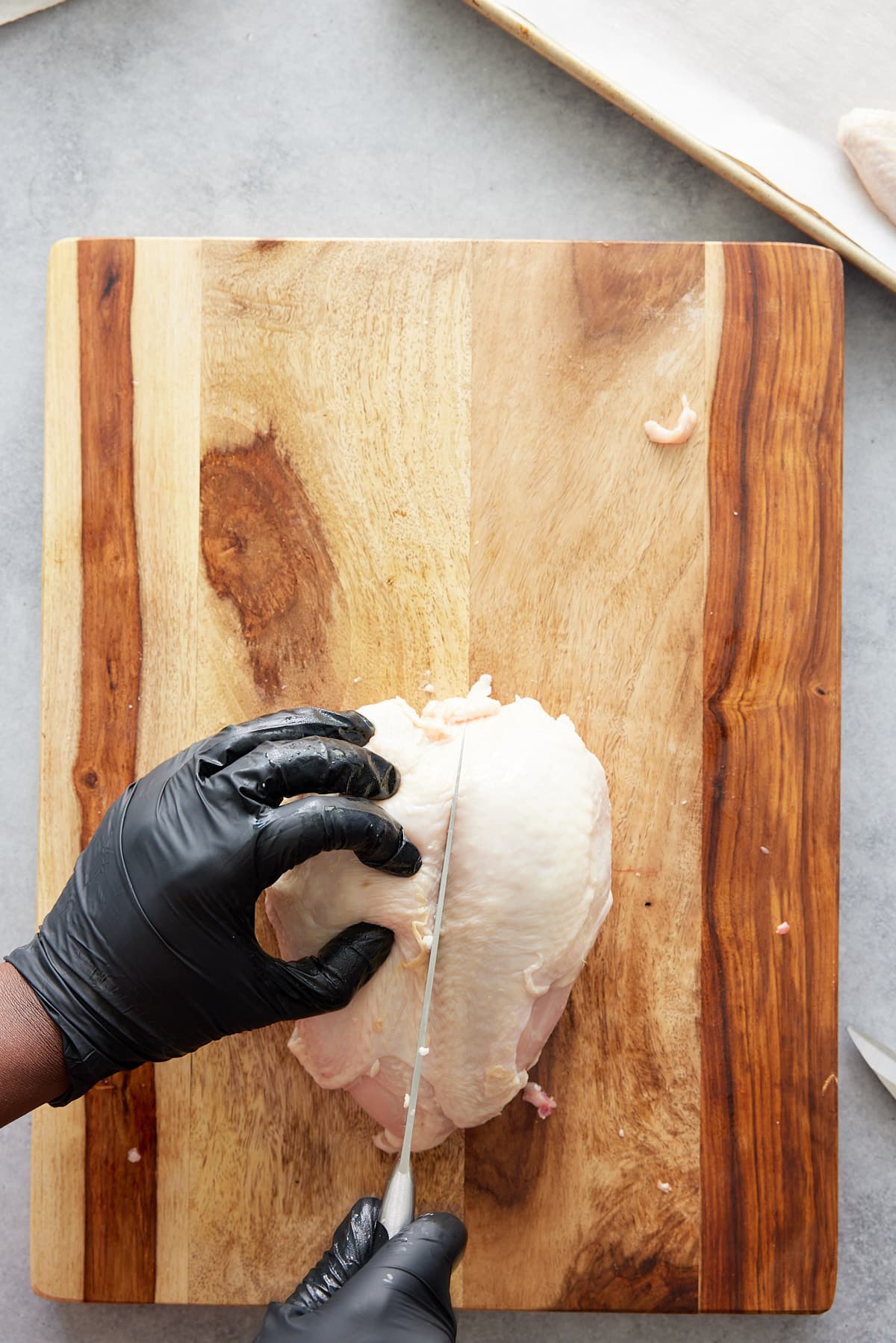 slicing between skin and meat of chicken breast