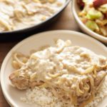 pork chop with gravy on a plate over rice