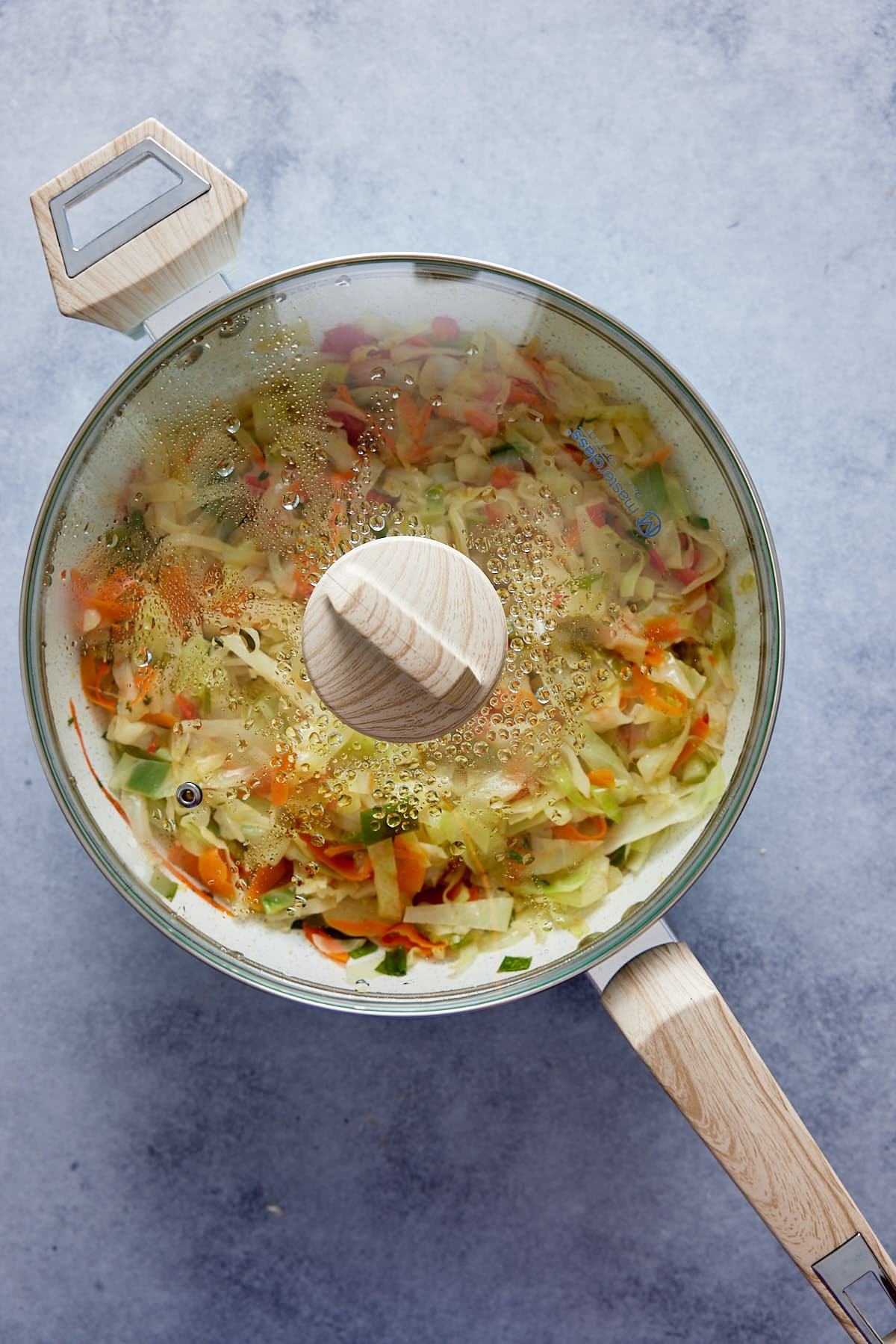 Jamaican cabbage in a skillet with a glass lid