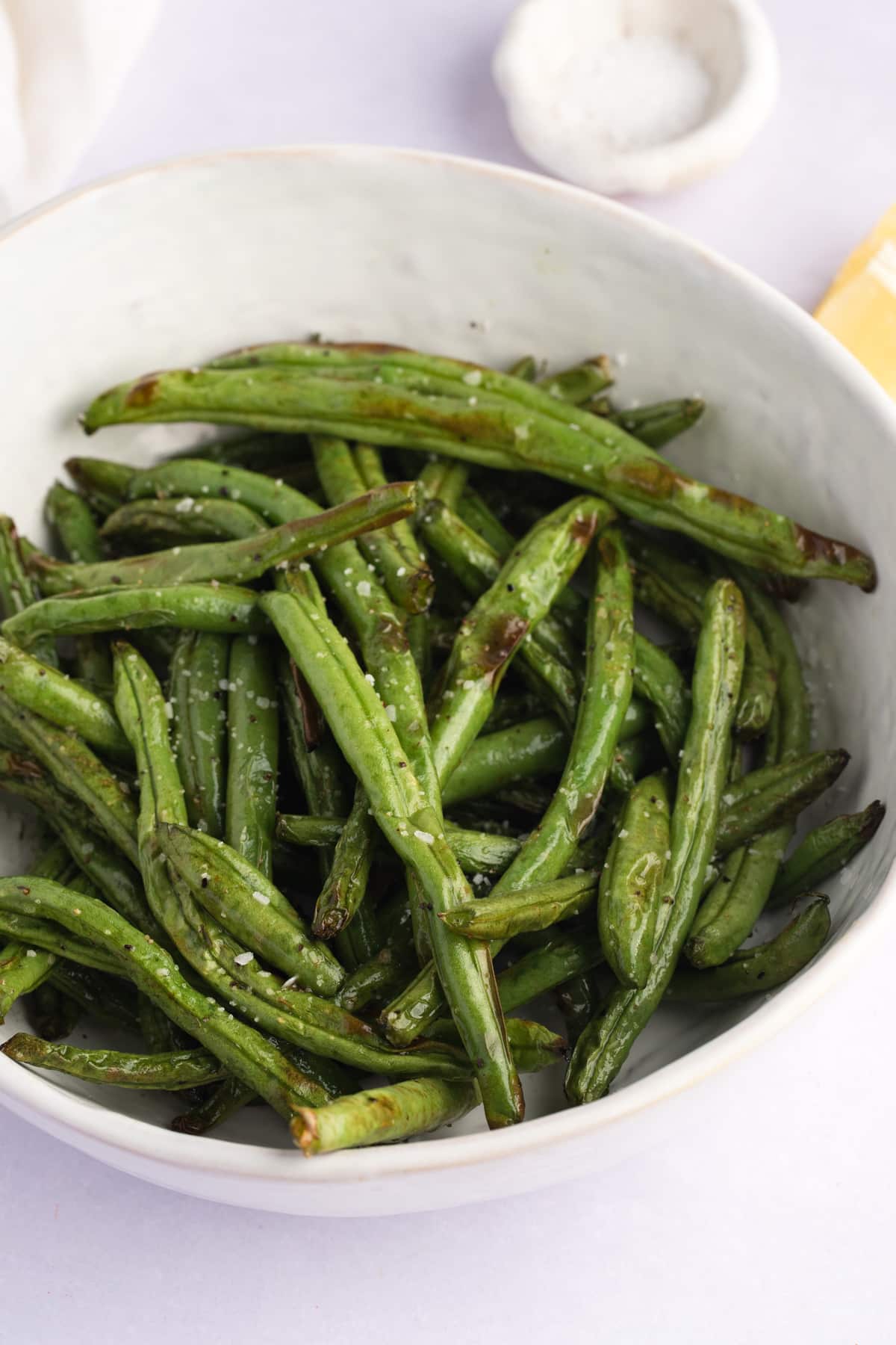 cooked green beans in a white serving bowl