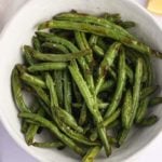 cooked green beans in a white serving bowl