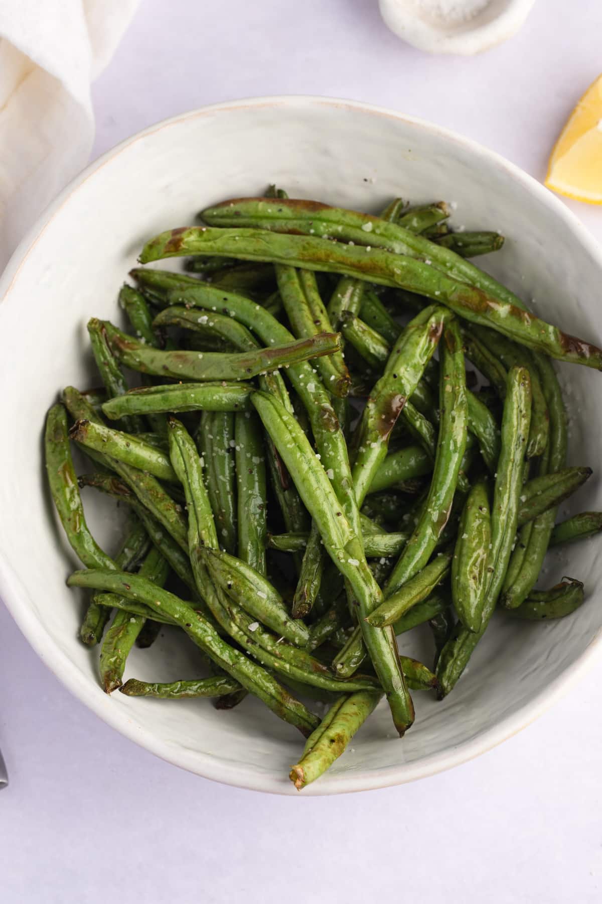cooked green beans in a white serving bowl