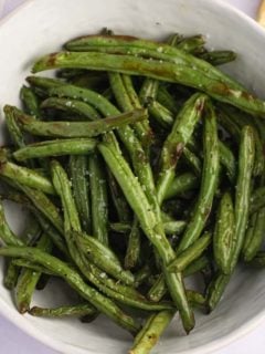 cooked green beans in a white serving bowl