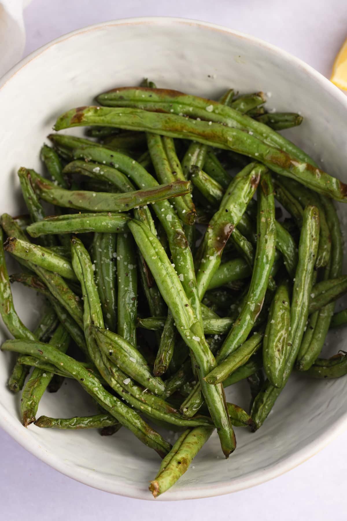 cooked green beans in a white serving bowl