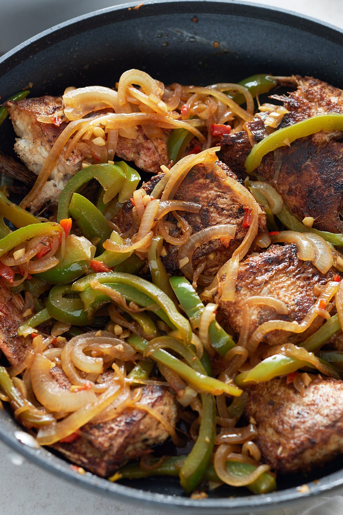 A close up image of a black skillet with brow stew fish