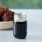 A jar filled with browning sauce set on a marble counter