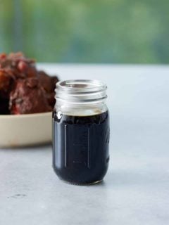 A jar filled with browning sauce set on a marble counter
