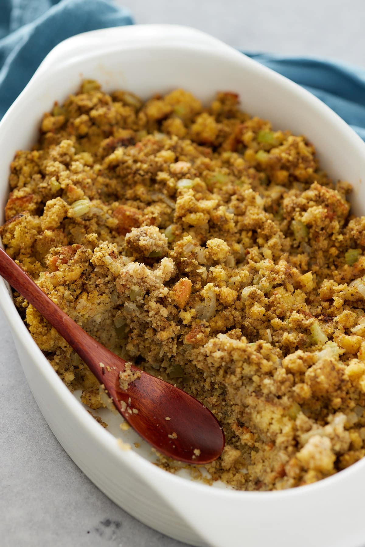 casserole scooped out of a baking dish with a wood spoon