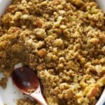 cornbread dressing scooped out of a baking dish with a wood spoon