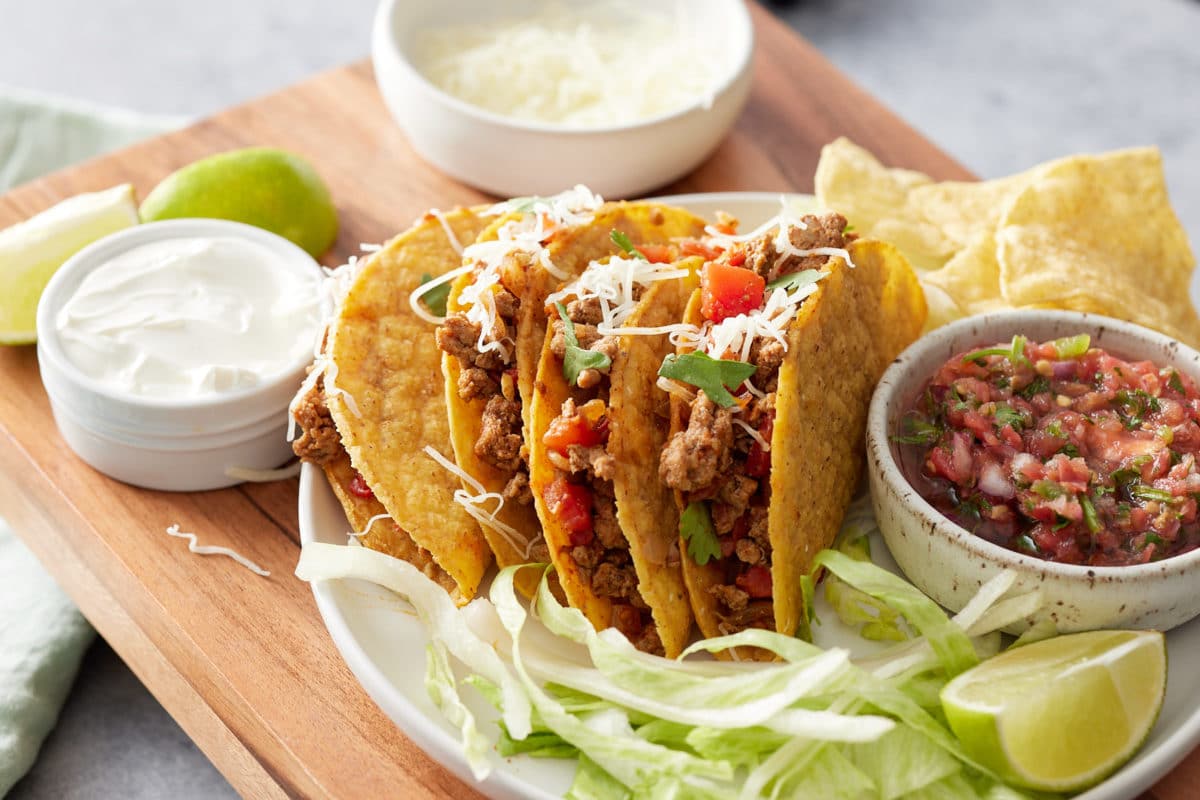tacos on plate surrounded by toppings