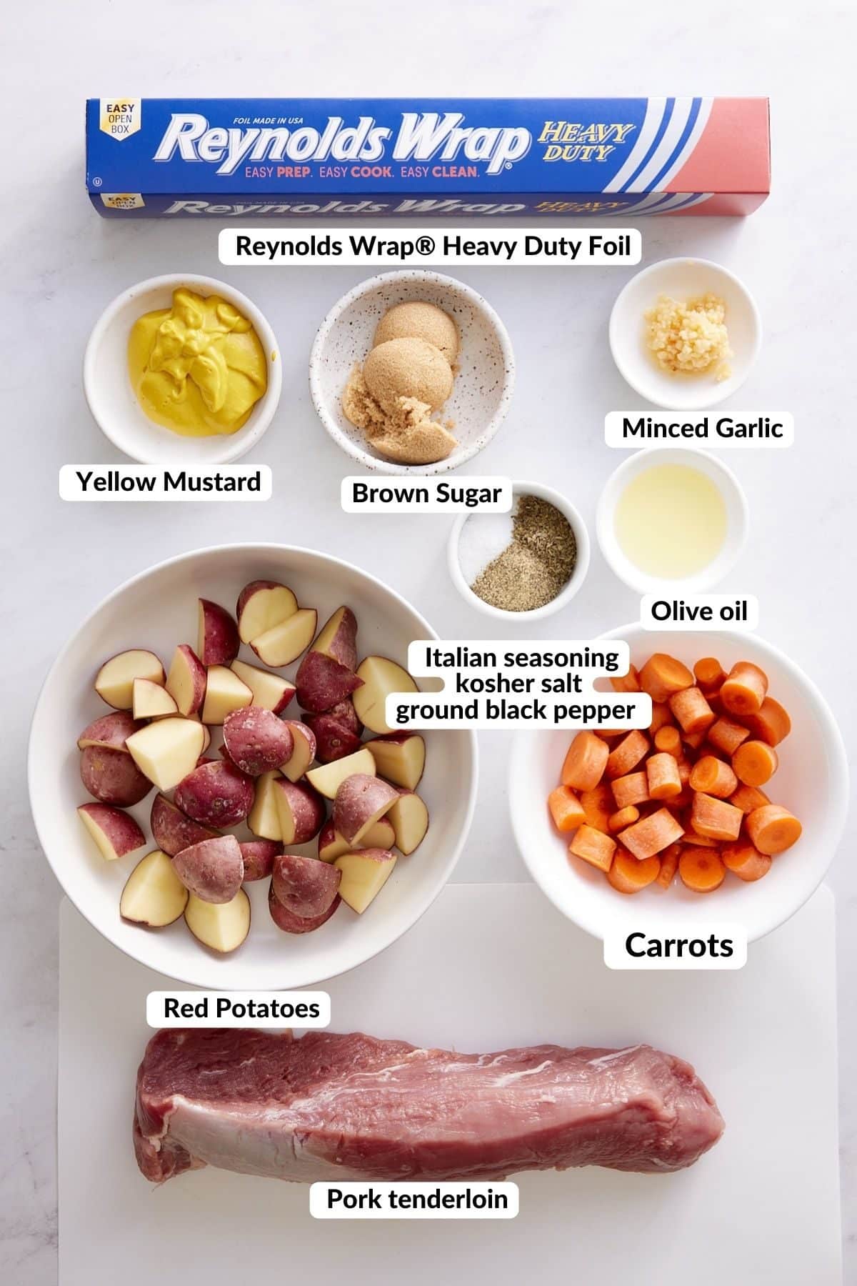 ingredients for pork tenderloin with carrots and potatoes on white background