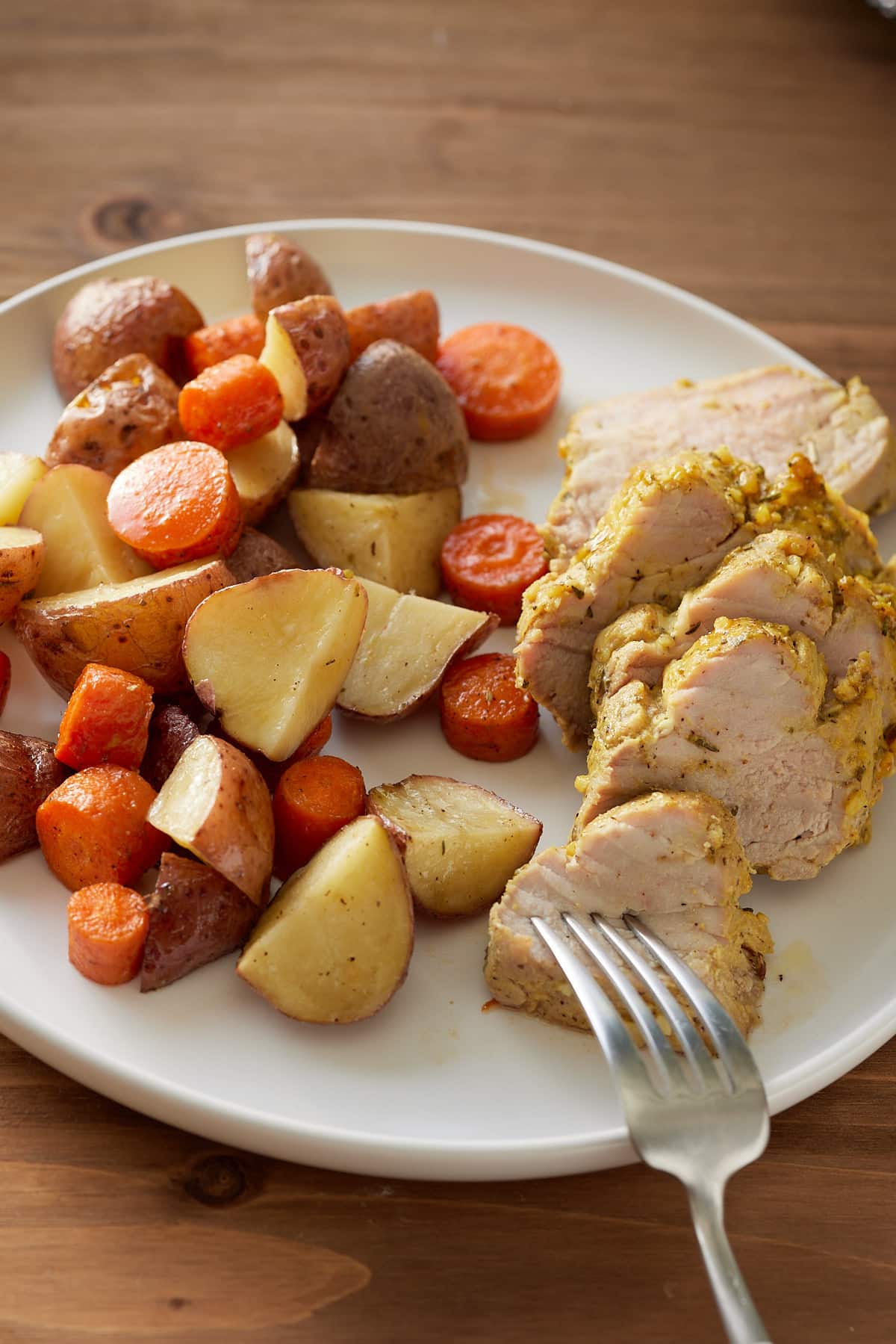 pork tenderloin on white plate with vegetables