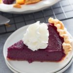 slice of purple sweet potato pie on a plate topped with whipped cream