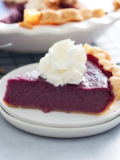 slice of purple sweet potato pie on a plate topped with whipped cream