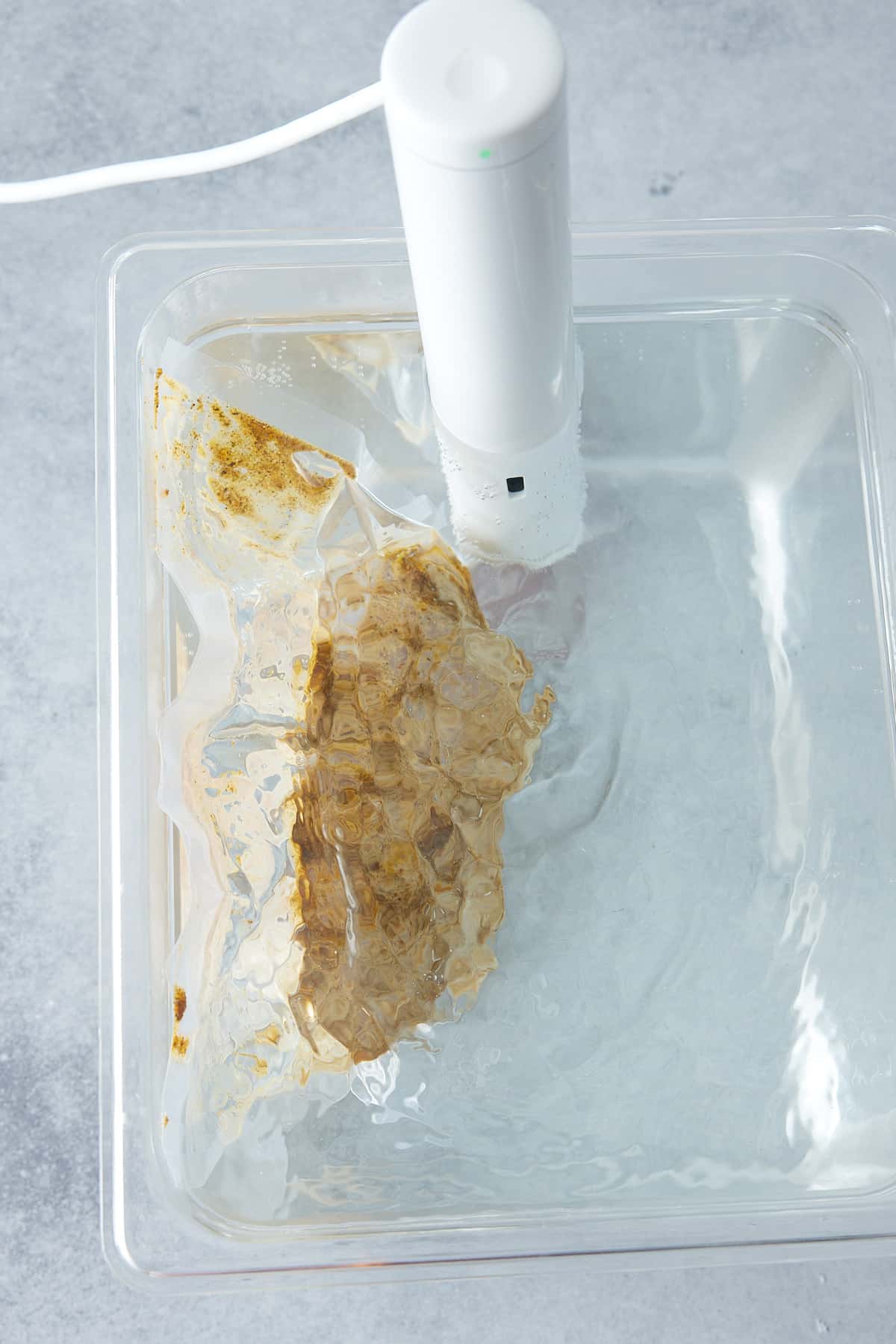 Water bath containing bag with whole turkey breast and immersion circulator attached