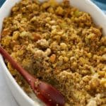 cornbread dressing scooped out of a baking dish with a wood spoon