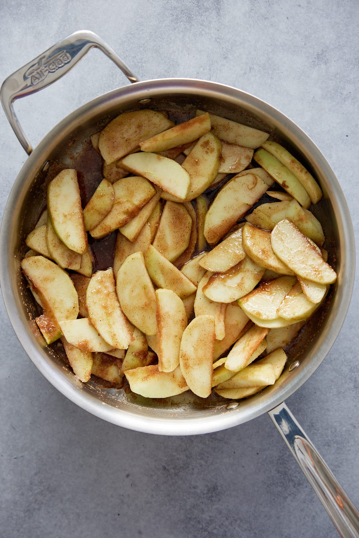 Pan with slices of raw apple covered in spiced brown butter