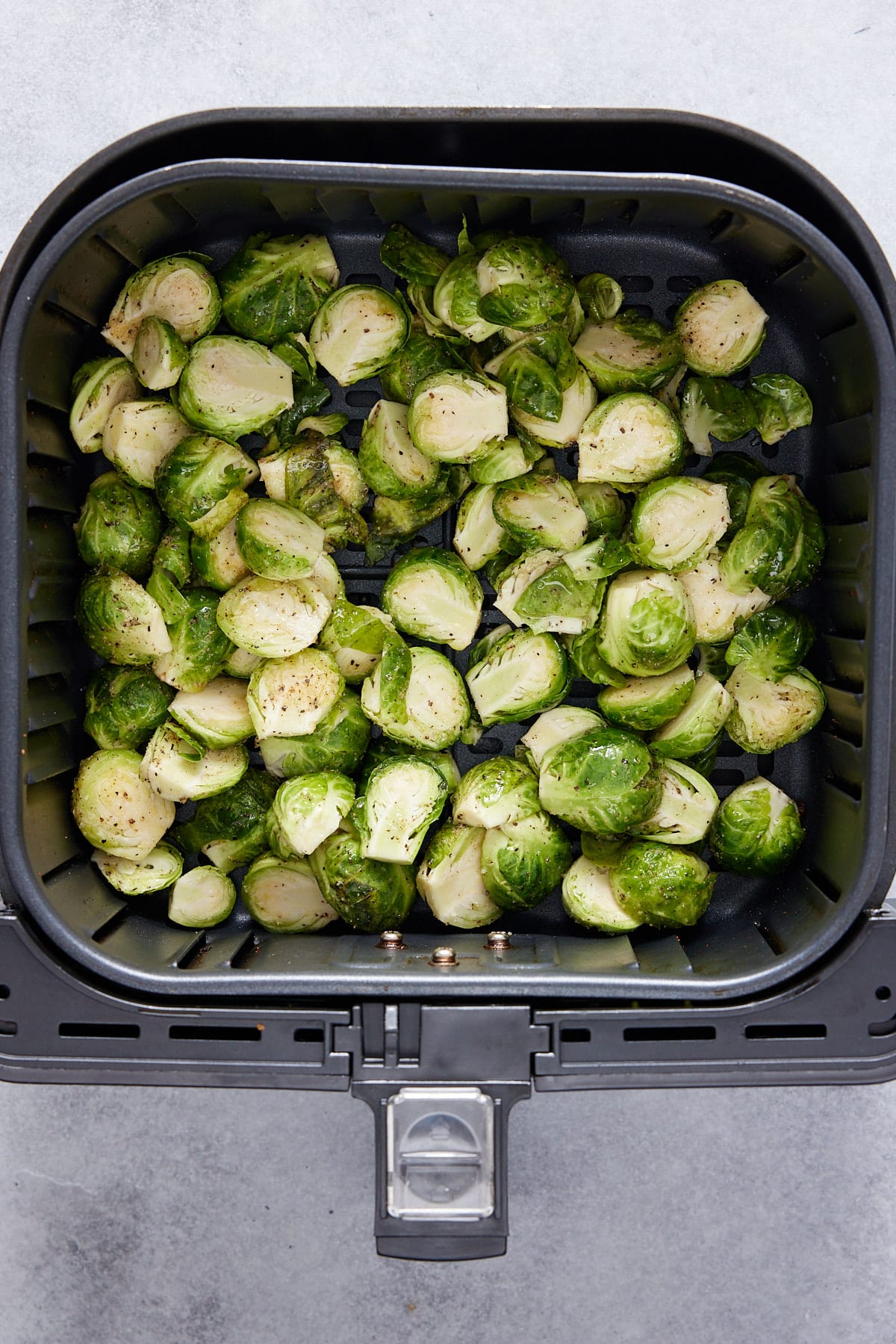 seasoned brussels sprouts in an air fryer basket