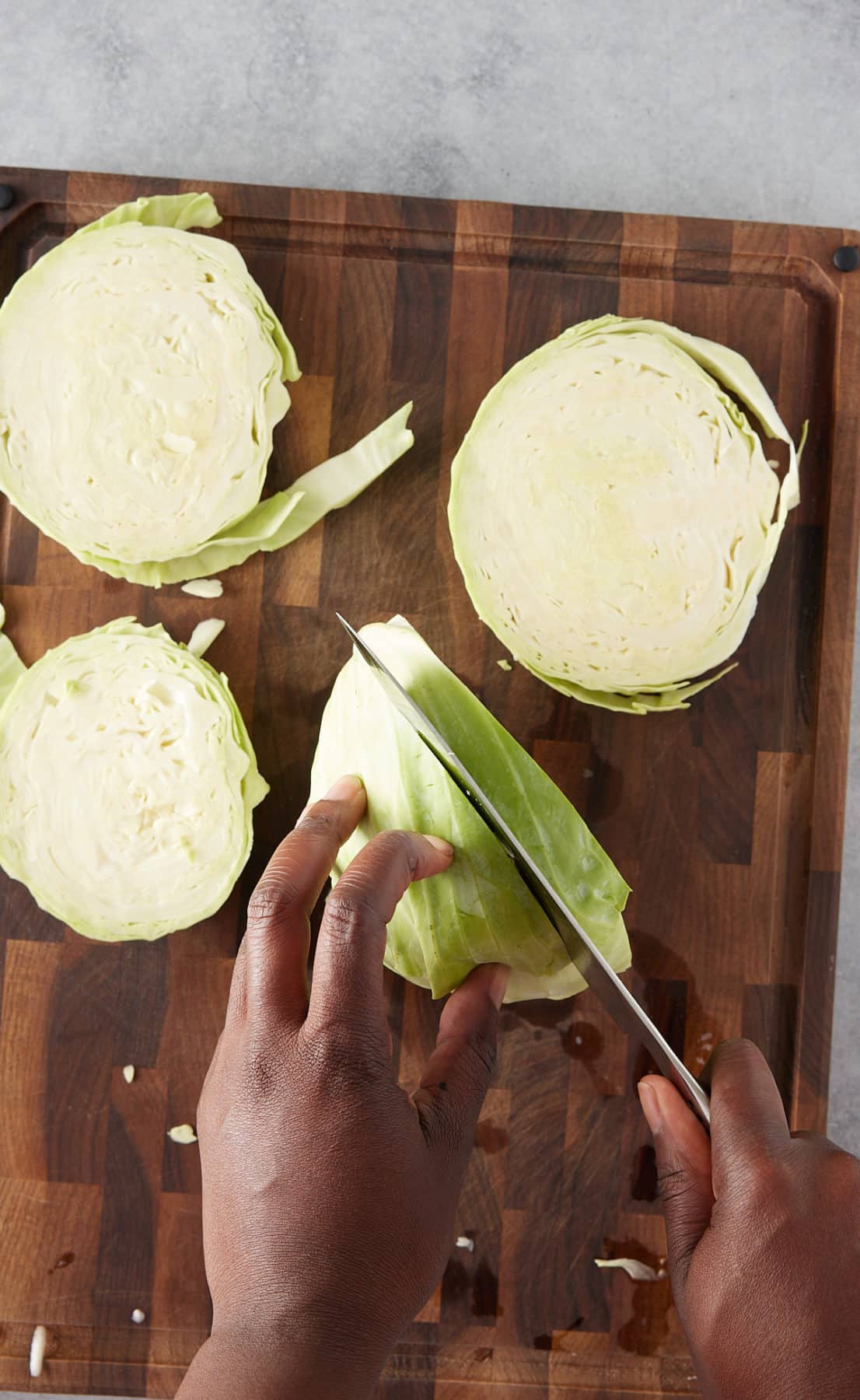 process of cutting cabbage steaks on a cutting board