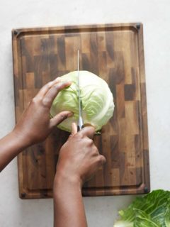 hand cutting cabbage in half