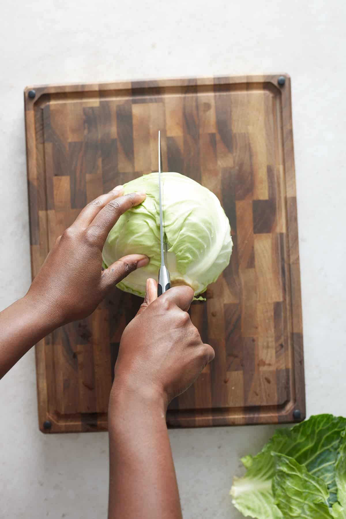 hand cutting cabbage in half