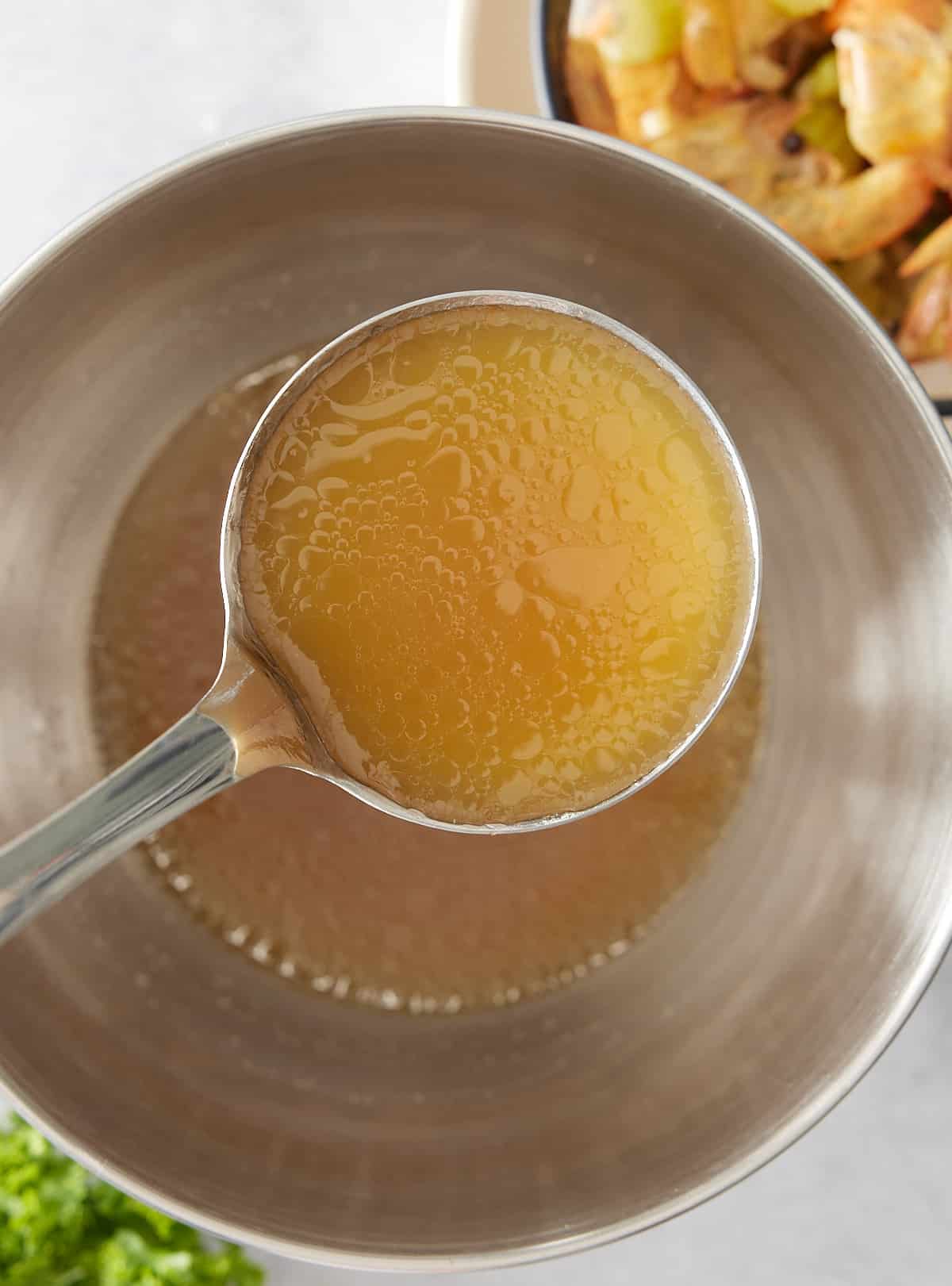 Silver bowl and ladle filled with shrimp stock