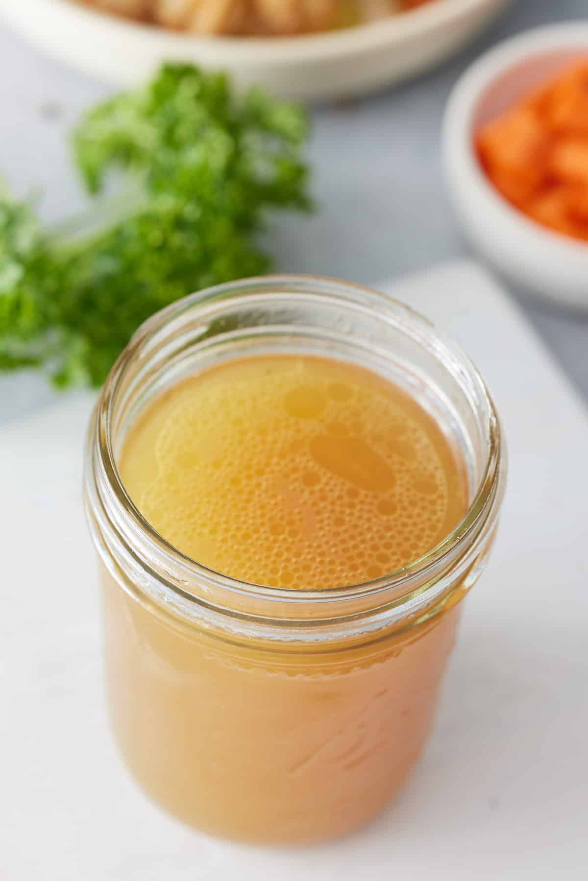 Top down image of jar of shrimp stock with recipe ingredients set in bowls alongside