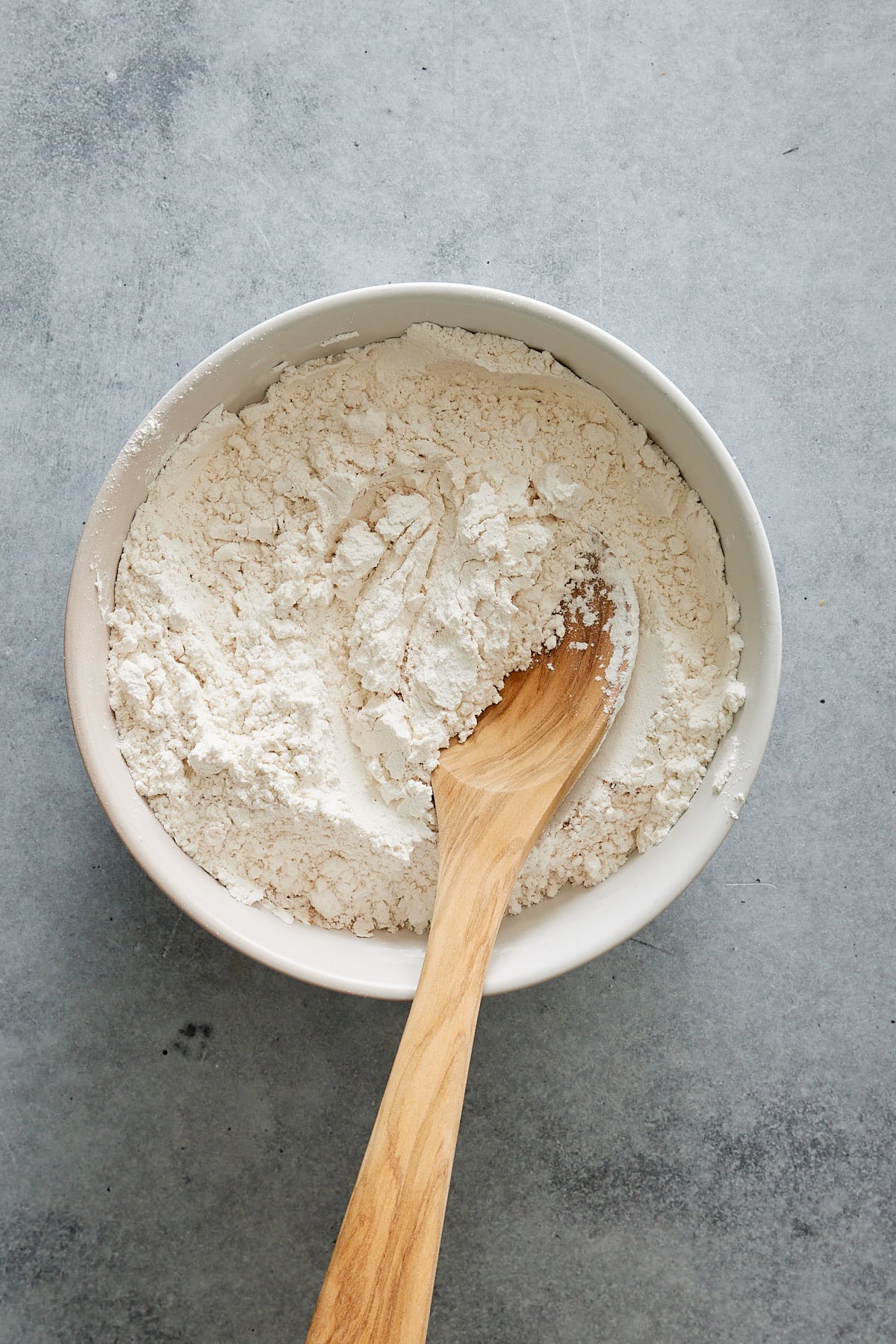 a bowl of flour, baking powder, pumpkin pie spice and salt. 