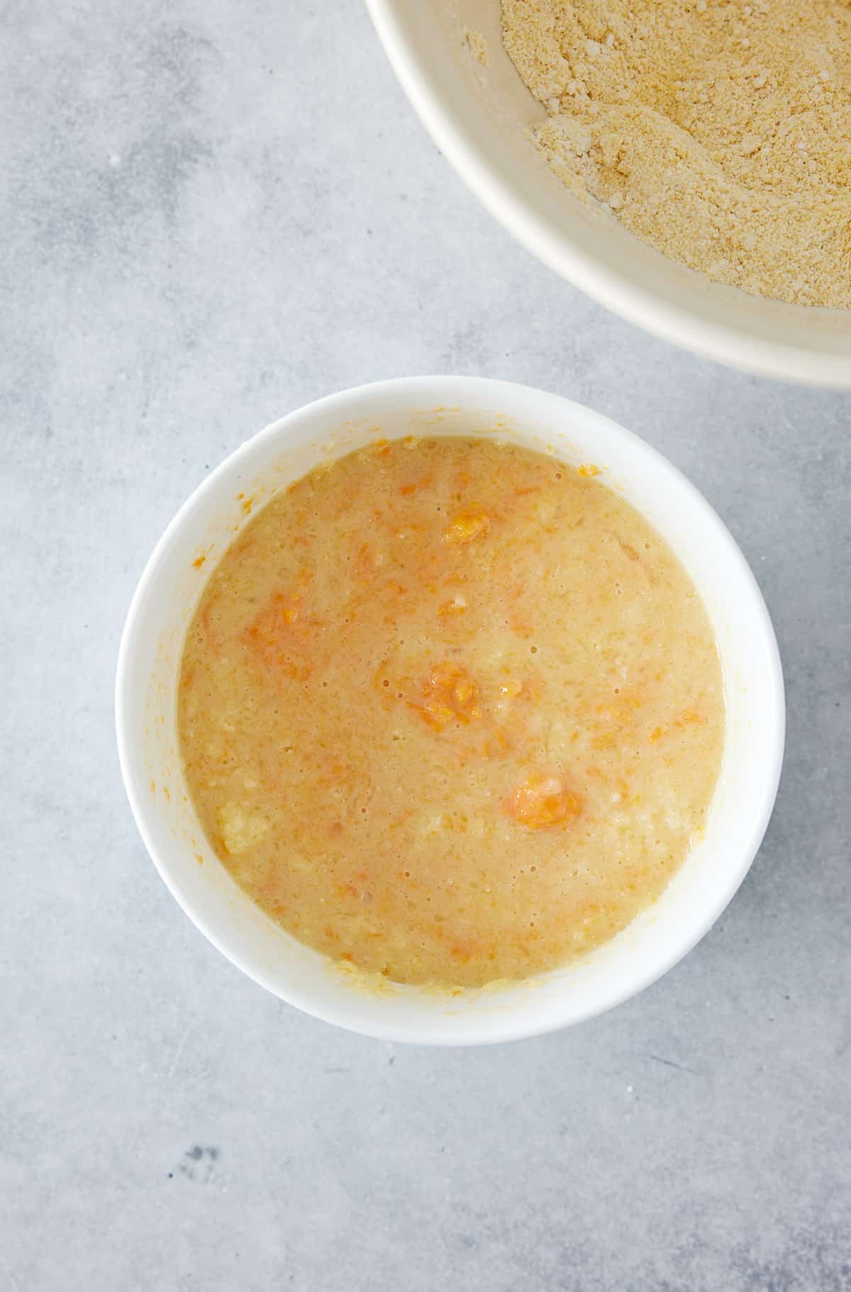 Small white bowl containing buttermilk, eggs, brown sugar and melted butter