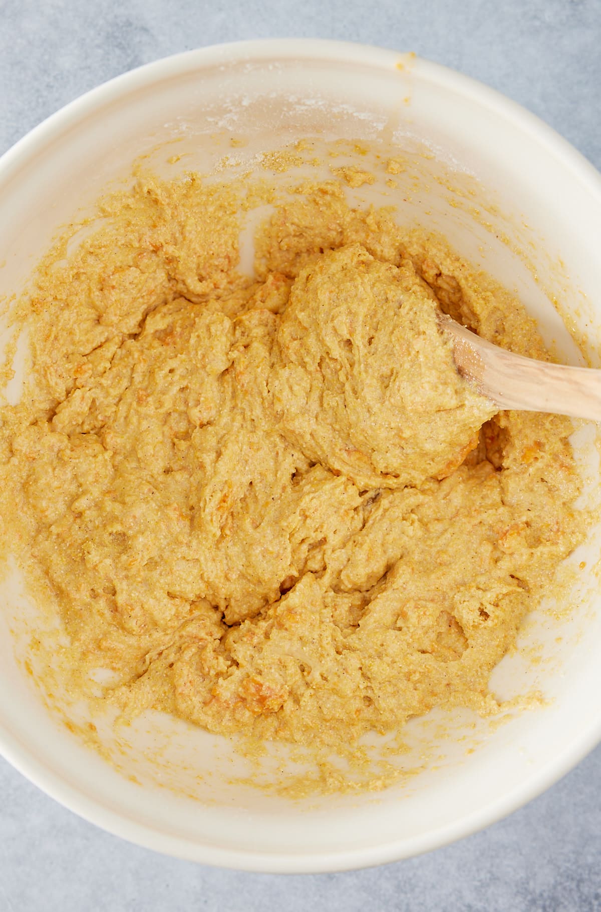 Large white mixing bowl with cornbread batter