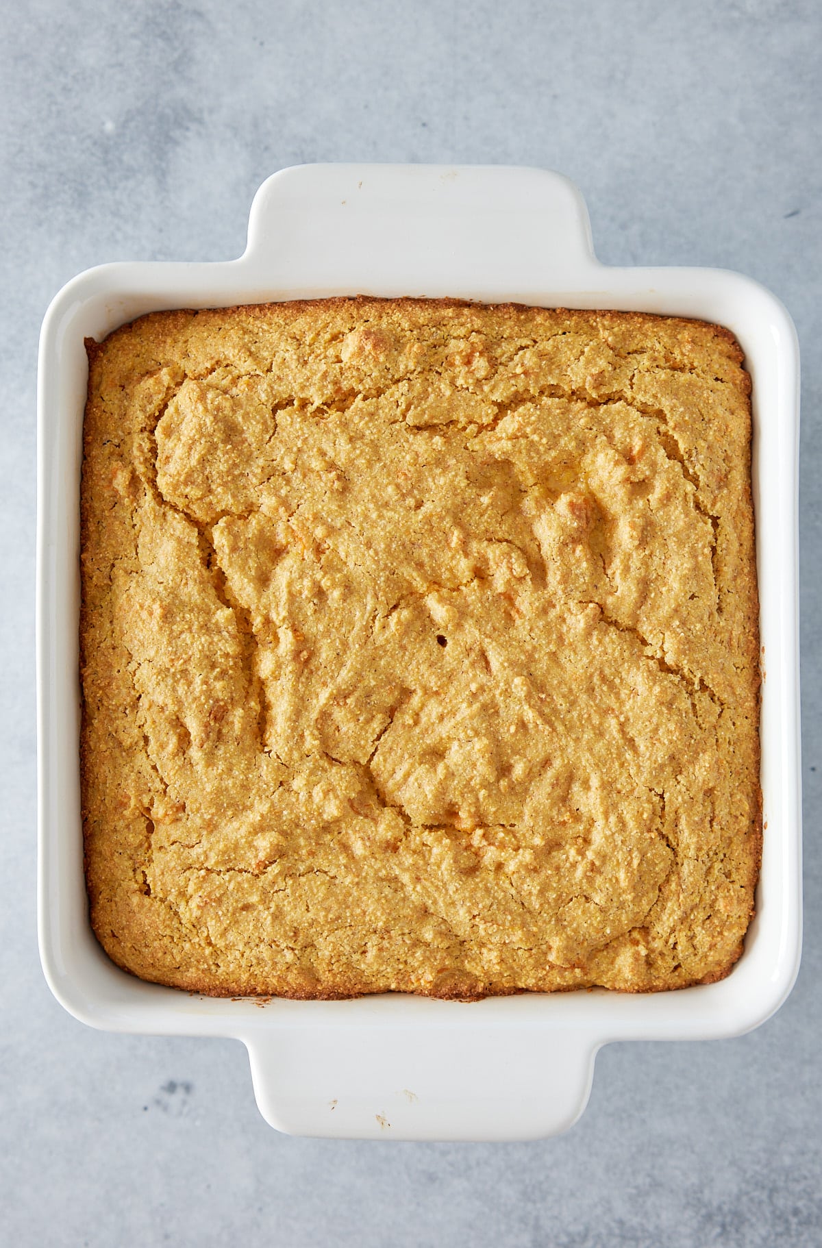 White square oven proof dish with baked sweet potato cornbread