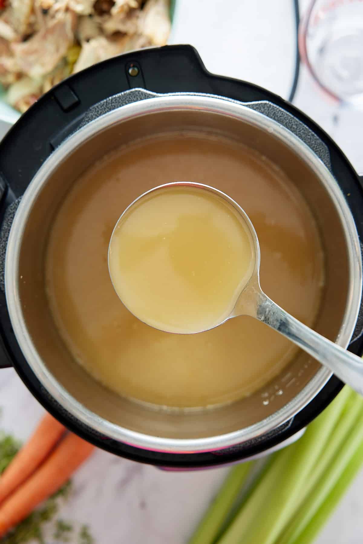 Pressure cooker and ladle filled with turkey broth