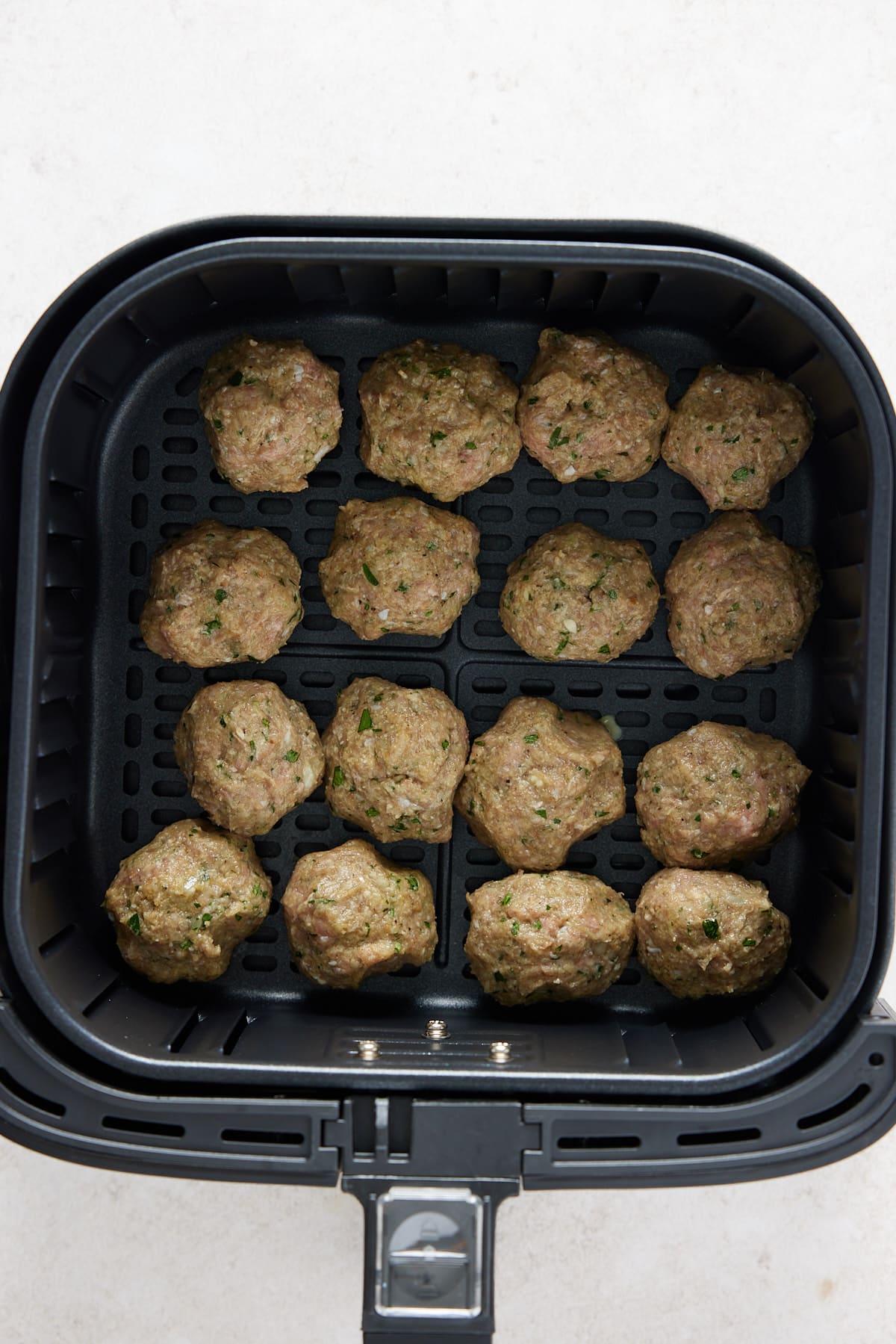 turkey meatballs sat in an air fryer basket before cooking