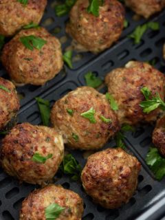 close up or turkey meatballs garnished in the air fryer basket