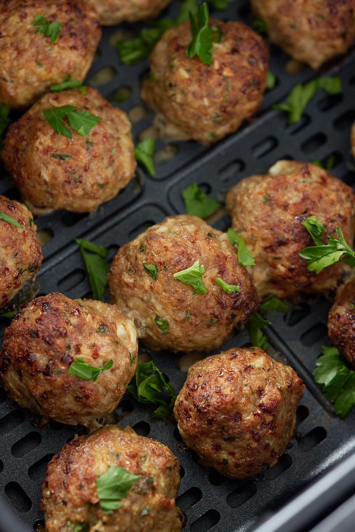 close up or turkey meatballs garnished in the air fryer basket