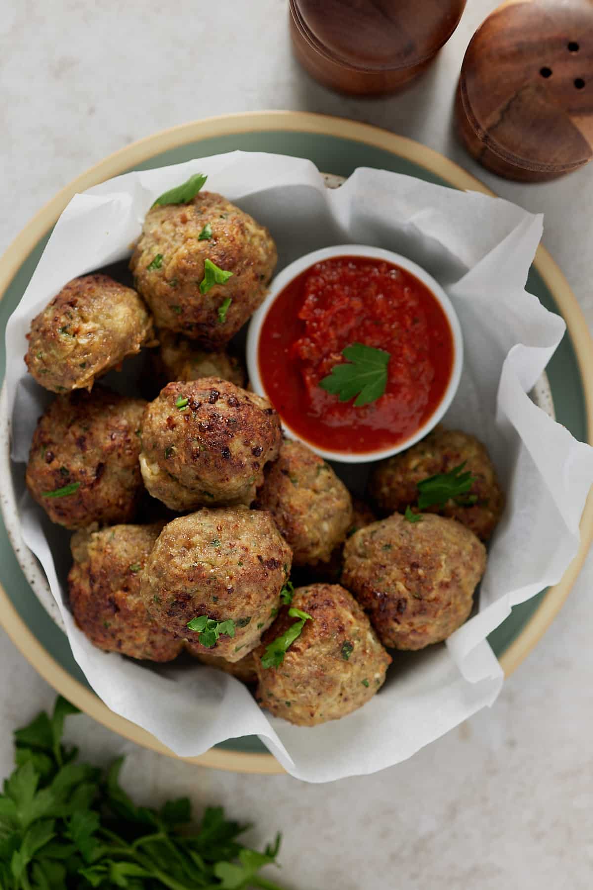 A bowl full of turkey meatballs along side a dip