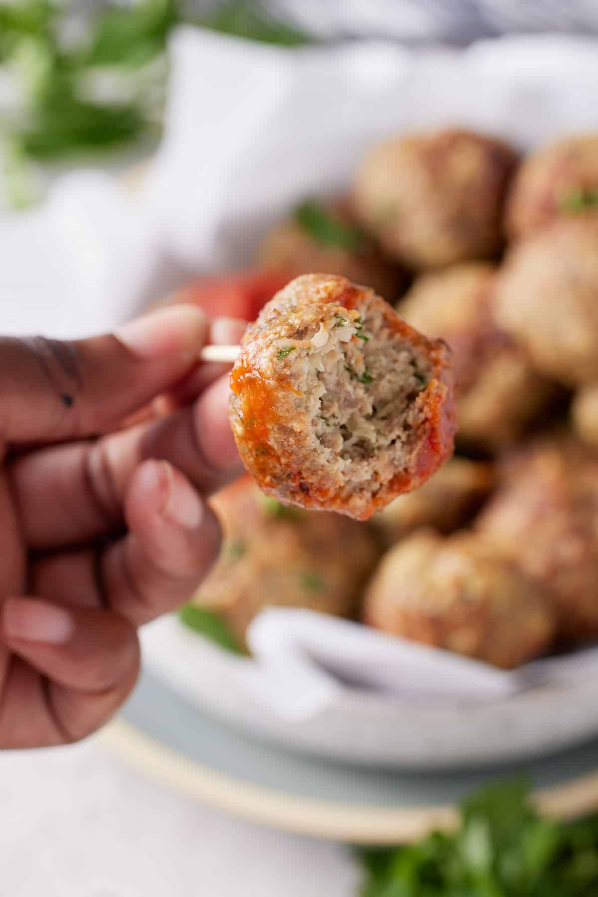 a turkey meatball with a bite taken out of it on a fork