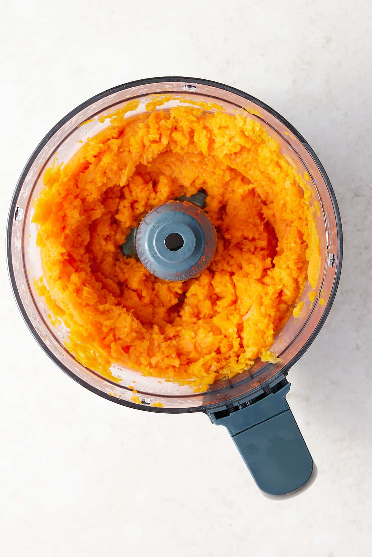 Food processor bowl filled with pureed carrot