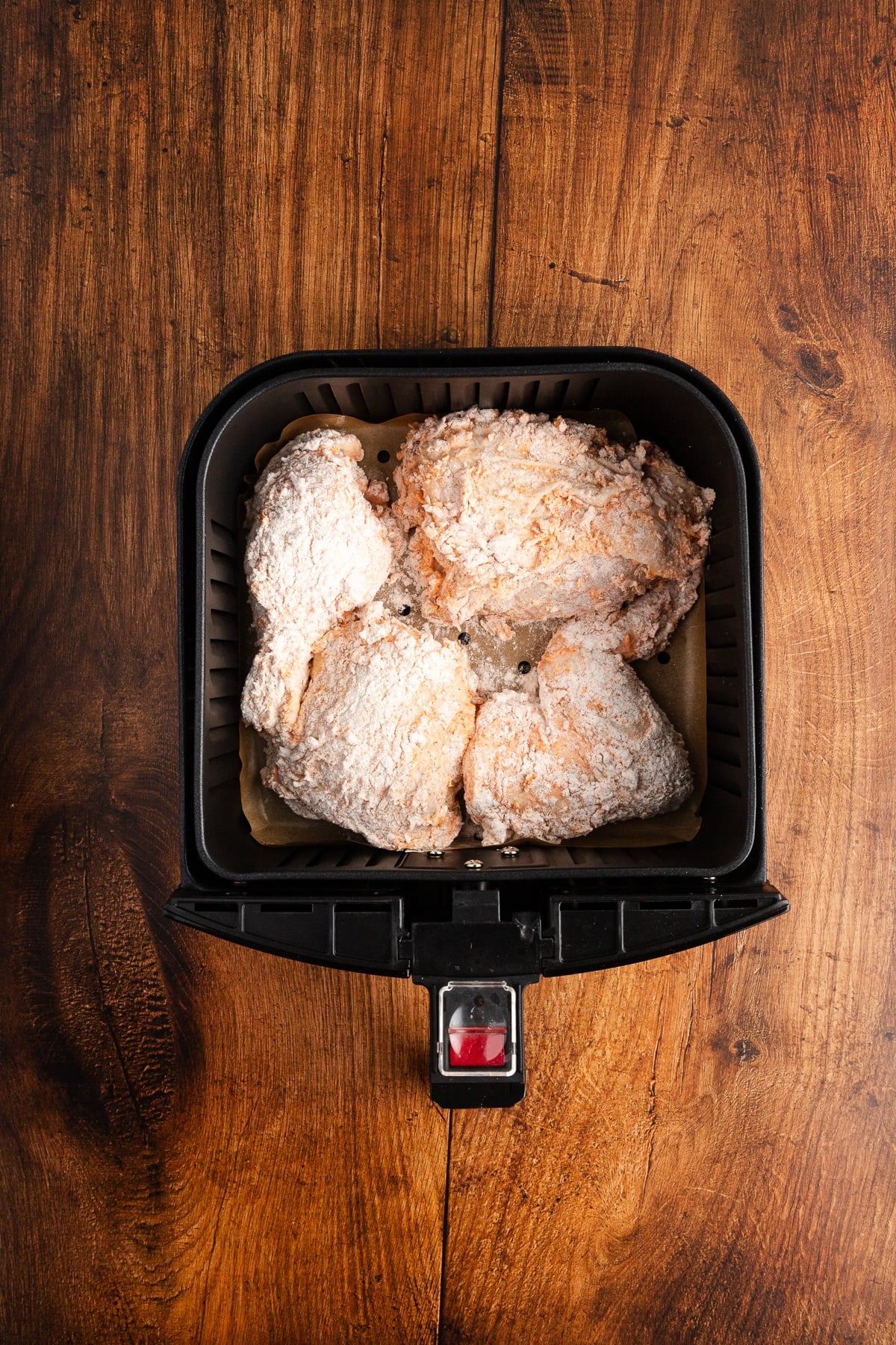 raw floured chicken in air fryer basket