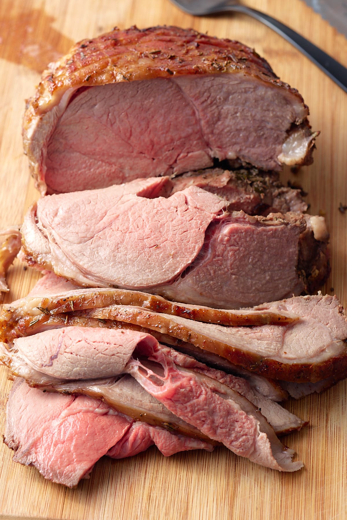 sliced leg of lamb on cutting board