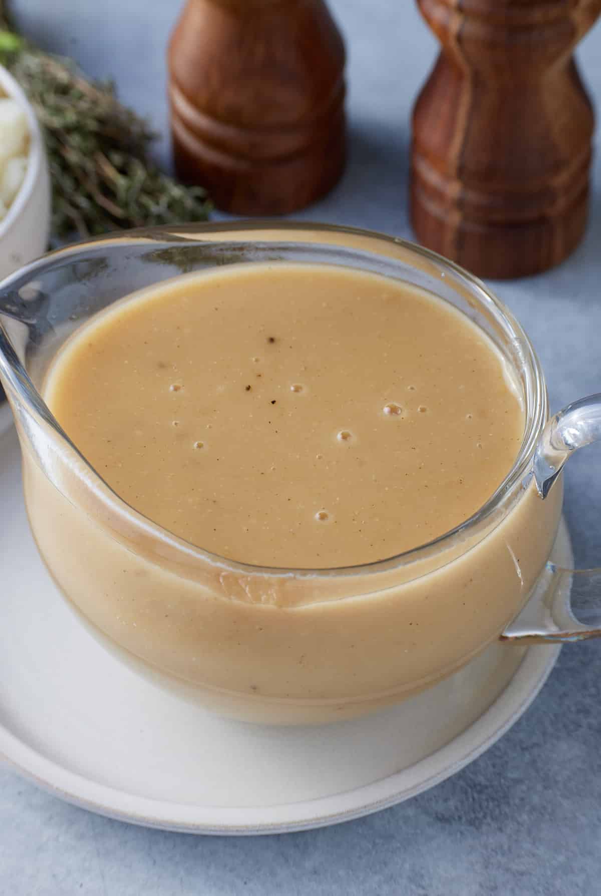 A glass gravy jug filled with brown gravy