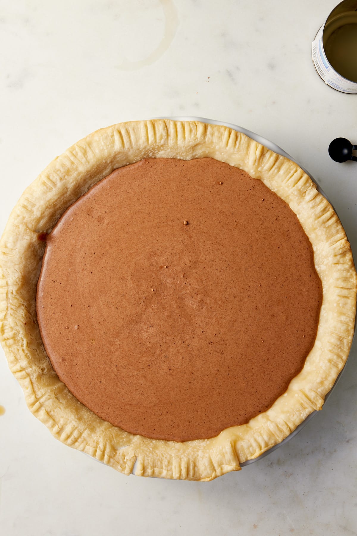 A pastry case filled with chocolate chess pie filling ready for the oven