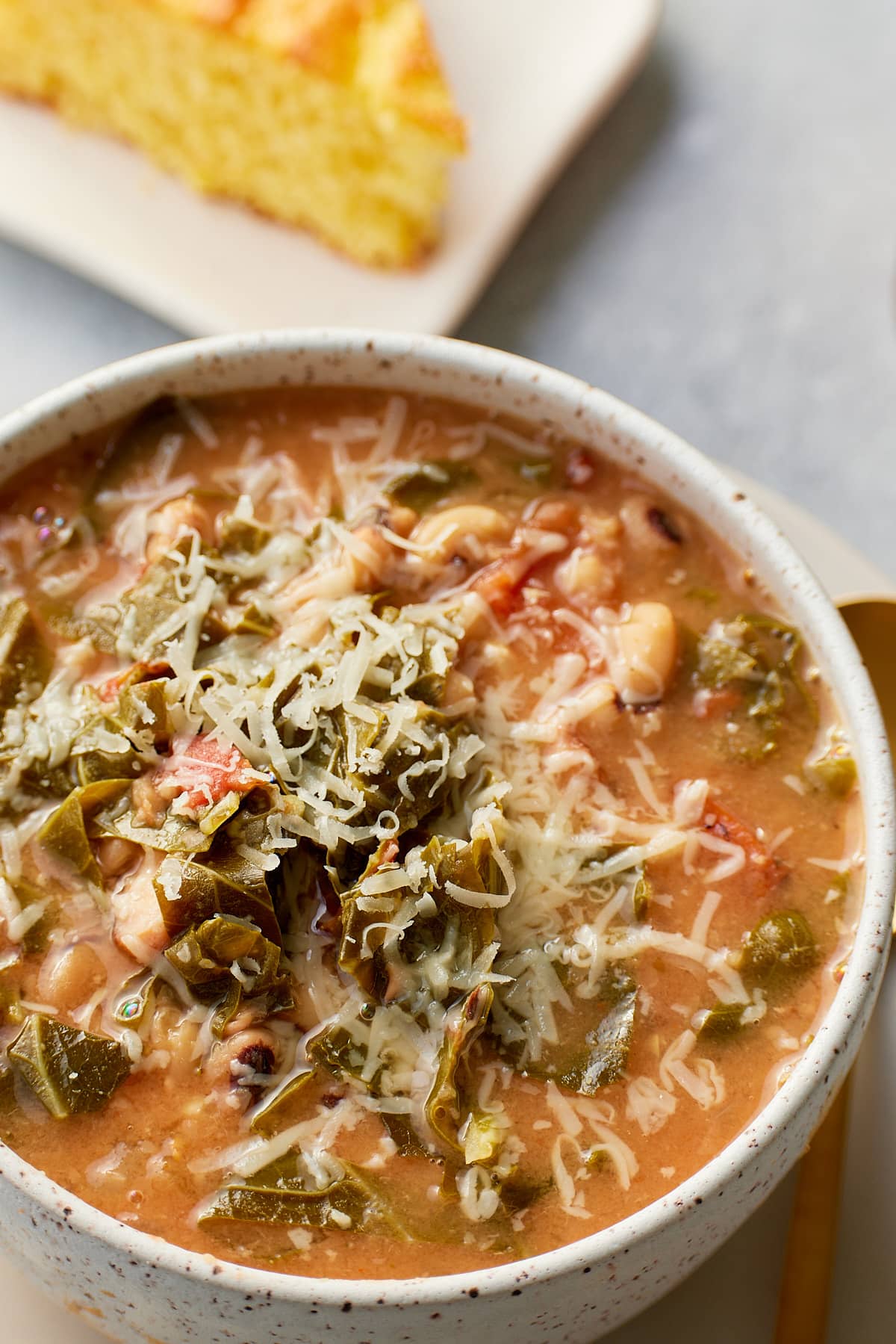 collard green soup in a bowl topped with cheese