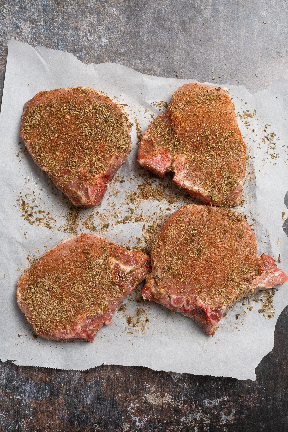 raw pork chops covered in seasoning