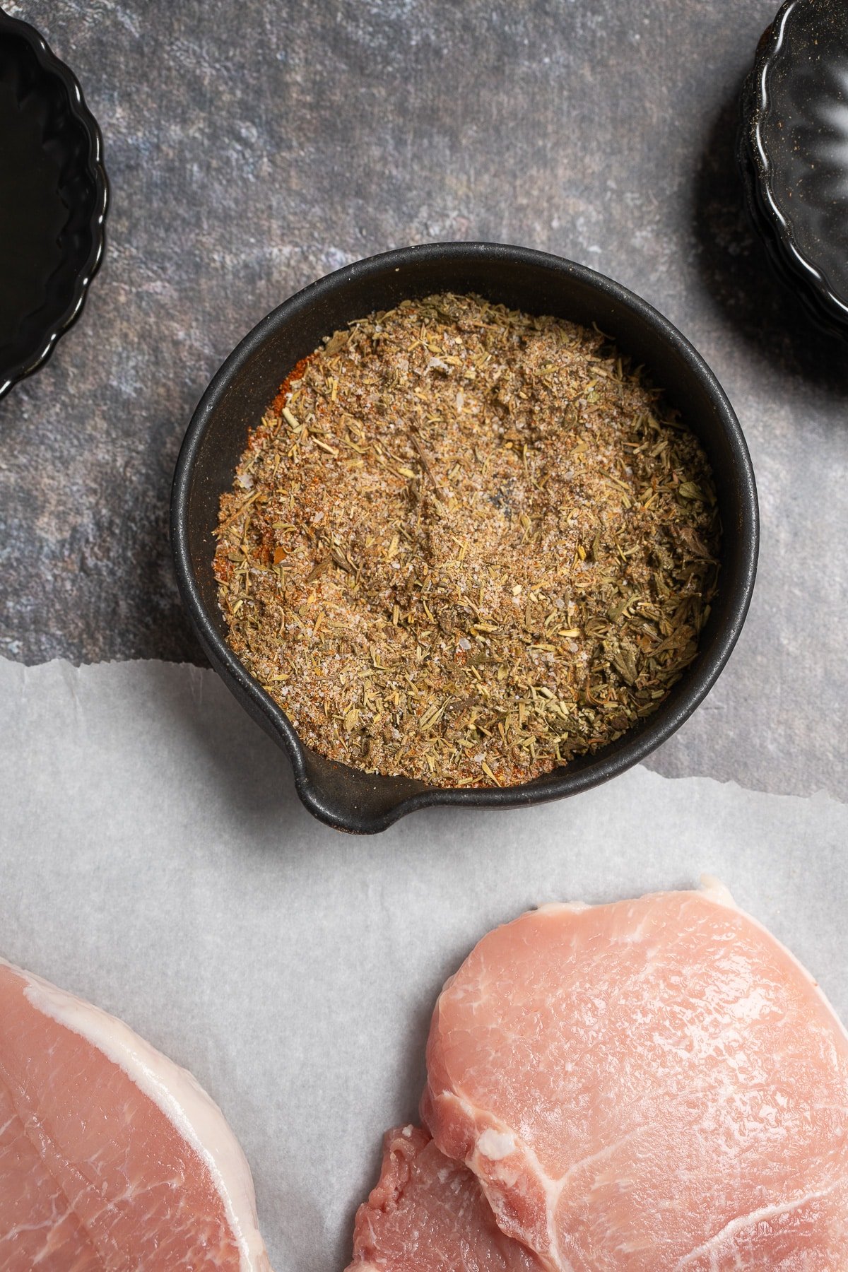 dry seasoning mixed in bowl next to pork chops