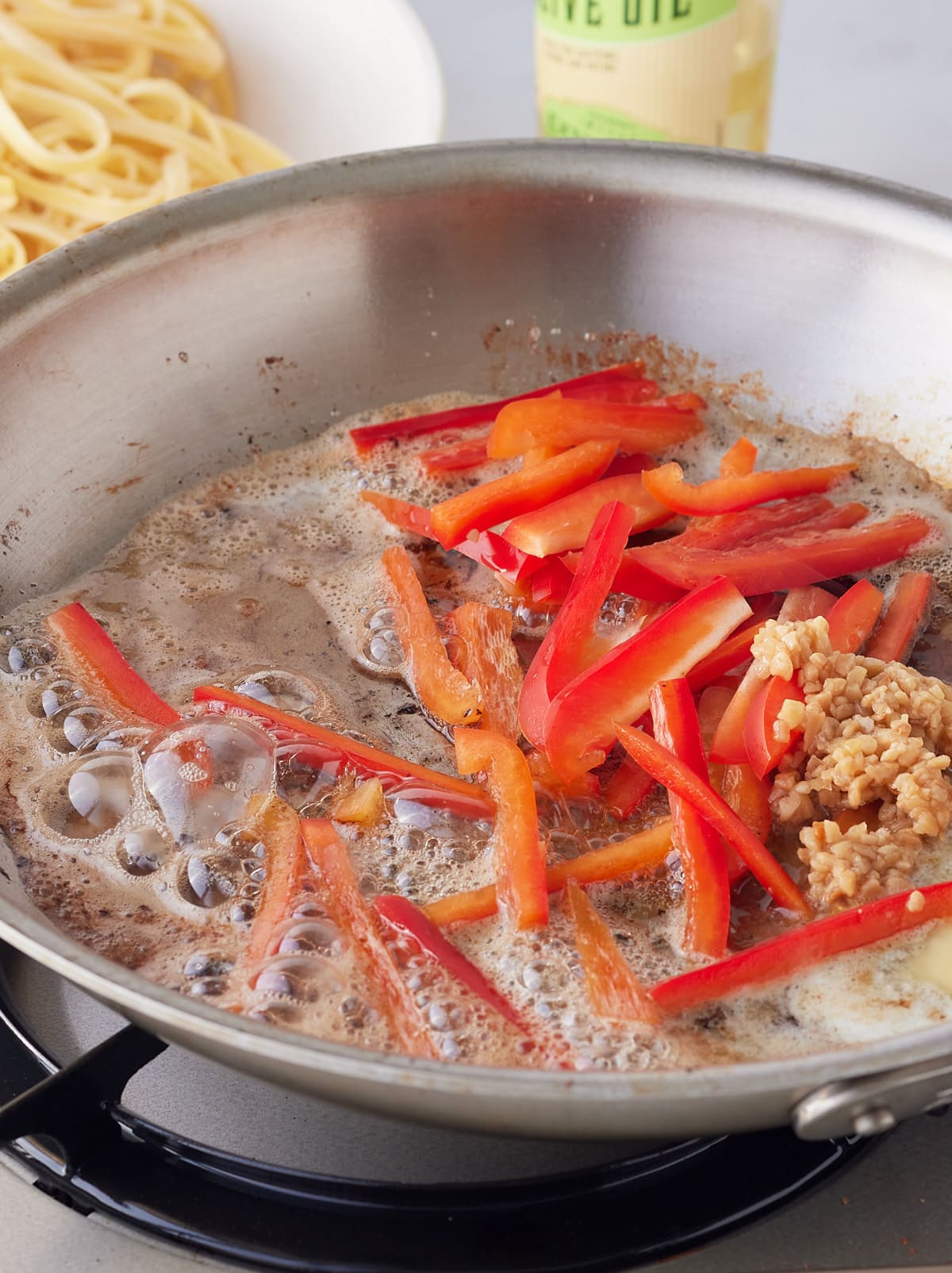 peppers and garlic added to the pan to cook